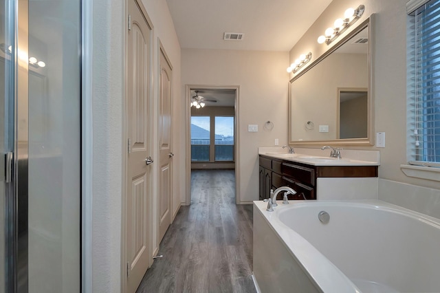 full bathroom with a garden tub, visible vents, a sink, and wood finished floors