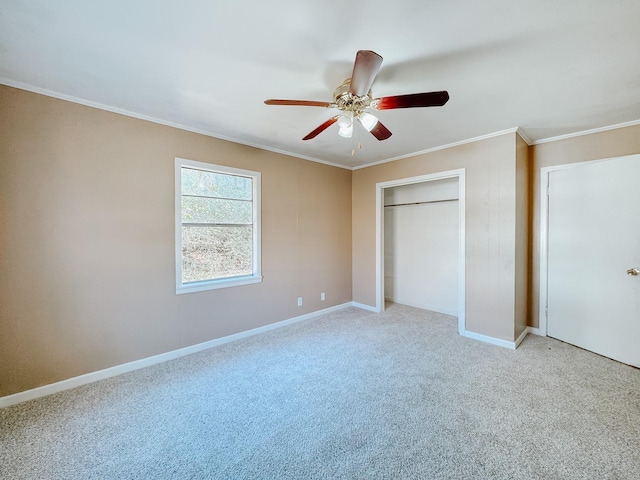 unfurnished bedroom with crown molding, carpet, baseboards, a closet, and a ceiling fan