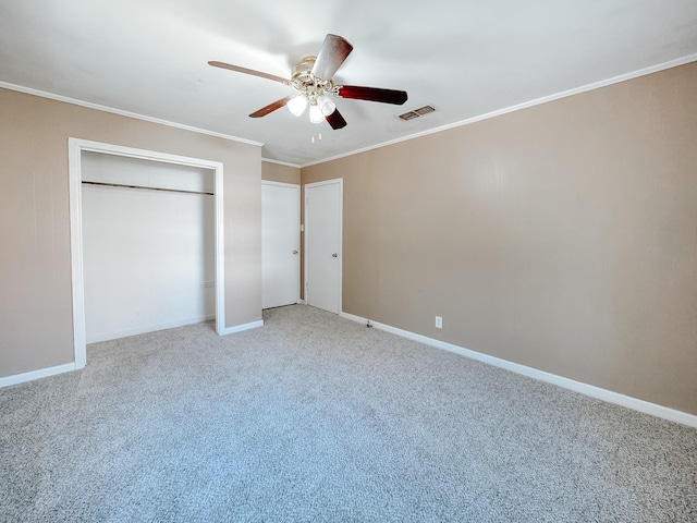 unfurnished bedroom featuring visible vents, a ceiling fan, crown molding, baseboards, and light colored carpet