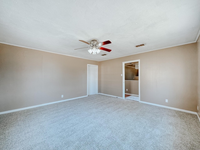 unfurnished bedroom featuring visible vents, carpet floors, crown molding, baseboards, and a ceiling fan