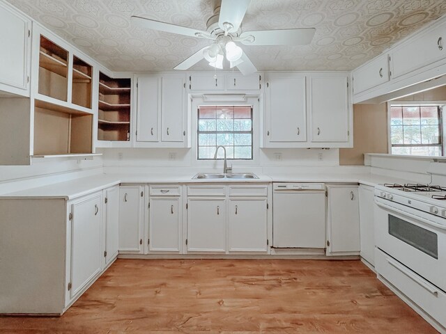 kitchen featuring white dishwasher, sink, white cabinetry, and light hardwood / wood-style flooring