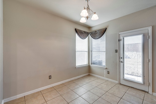 interior space with baseboards, a notable chandelier, and light tile patterned flooring