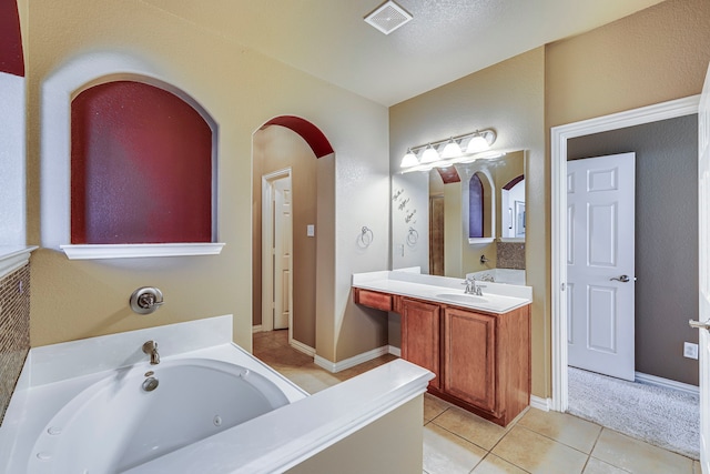 full bath featuring visible vents, baseboards, a jetted tub, tile patterned flooring, and vanity