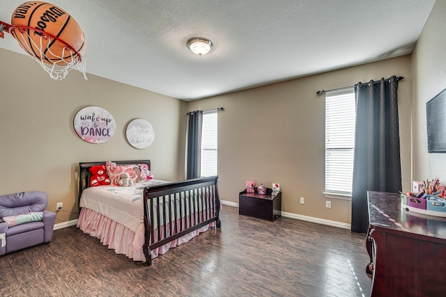 bedroom with dark wood-style floors, multiple windows, and baseboards