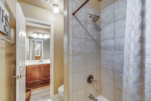 full bath featuring toilet, shower / bath combo with shower curtain, and vanity