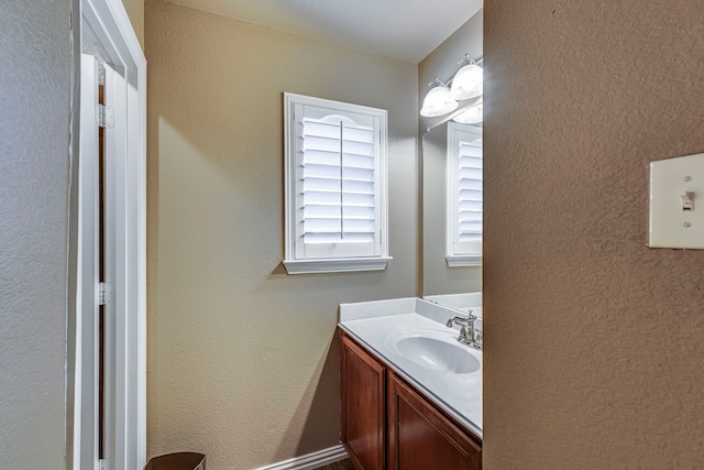 bathroom with a textured wall and vanity