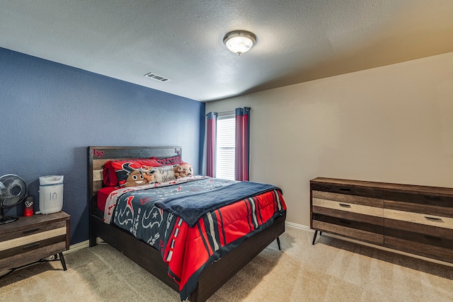 carpeted bedroom featuring a textured ceiling, visible vents, and baseboards