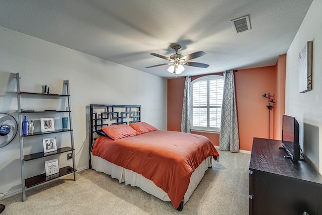 bedroom with a textured ceiling, a ceiling fan, visible vents, and baseboards