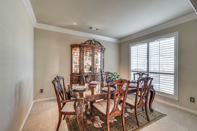 dining area with baseboards, ornamental molding, visible vents, and light colored carpet