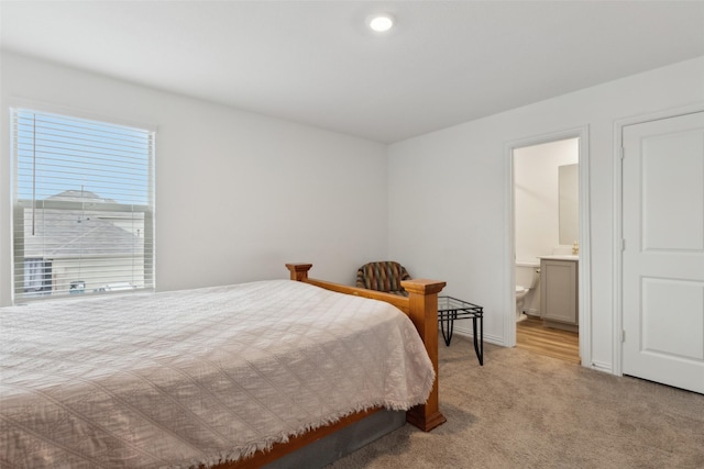 carpeted bedroom featuring ensuite bath