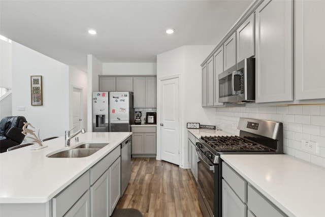 kitchen with sink, dark wood-type flooring, gray cabinets, and appliances with stainless steel finishes