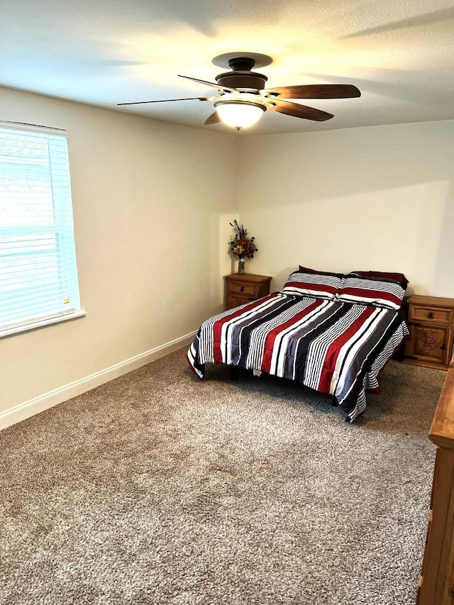 carpeted bedroom with ceiling fan and a textured ceiling