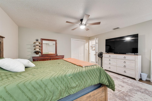 bedroom with ceiling fan, a closet, and a textured ceiling