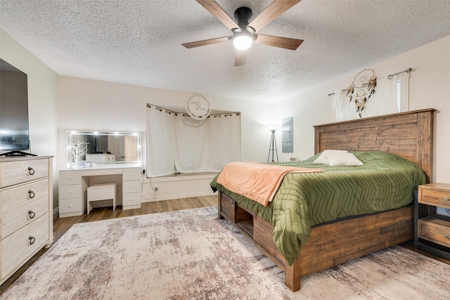 1714 Vz County Road 2142 Unit 2142, Wills Point, TX 75169 - bedroom with a textured ceiling, wood finished floors, a ceiling fan, and electric panel