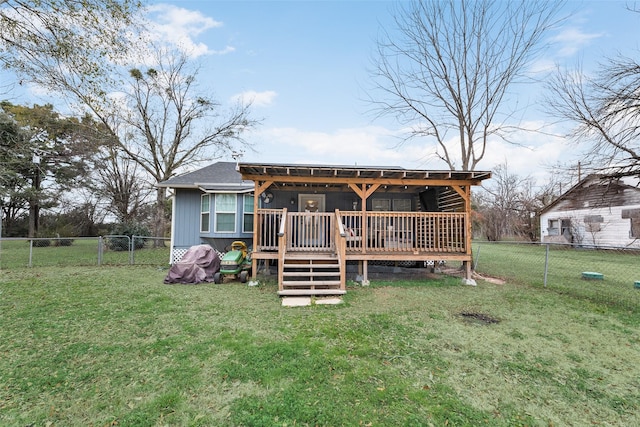 rear view of property featuring a deck and a lawn