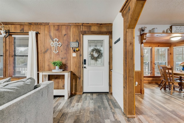 foyer entrance with hardwood / wood-style flooring and wood walls