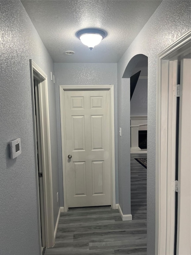 corridor featuring dark hardwood / wood-style floors and a textured ceiling