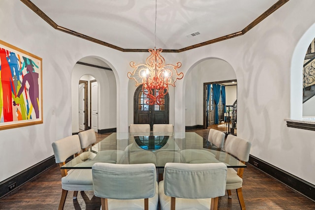 dining space with an inviting chandelier, ornamental molding, and dark hardwood / wood-style flooring