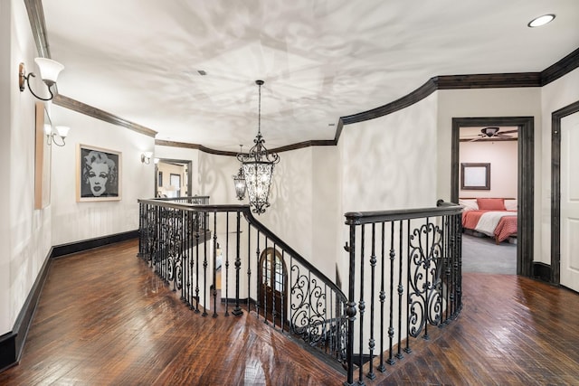 corridor with a notable chandelier, crown molding, and dark hardwood / wood-style floors