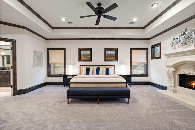 bedroom featuring crown molding, light colored carpet, and a tray ceiling