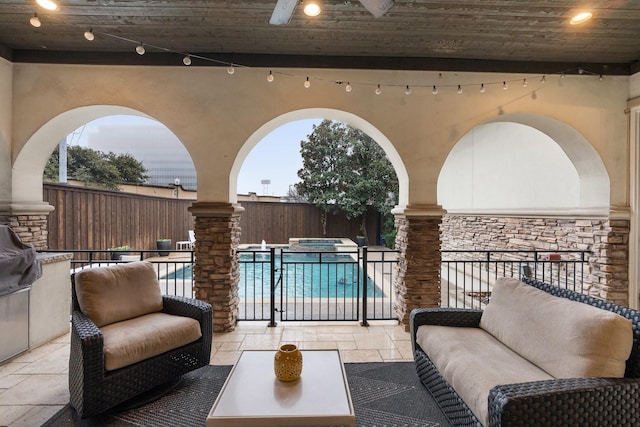 view of patio / terrace with a fenced backyard, a pool with connected hot tub, and a ceiling fan