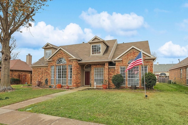 view of front of home with cooling unit and a front lawn