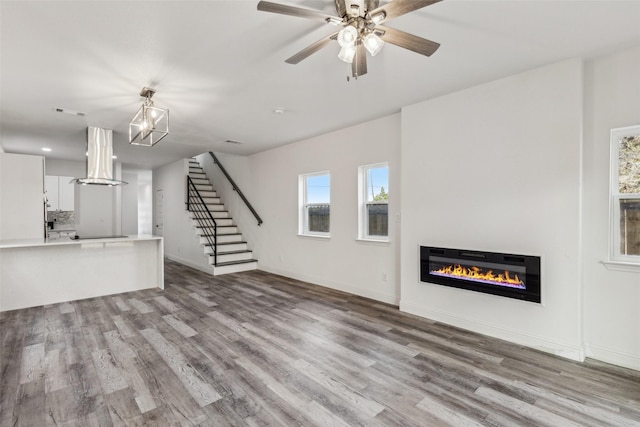 unfurnished living room with ceiling fan and light wood-type flooring