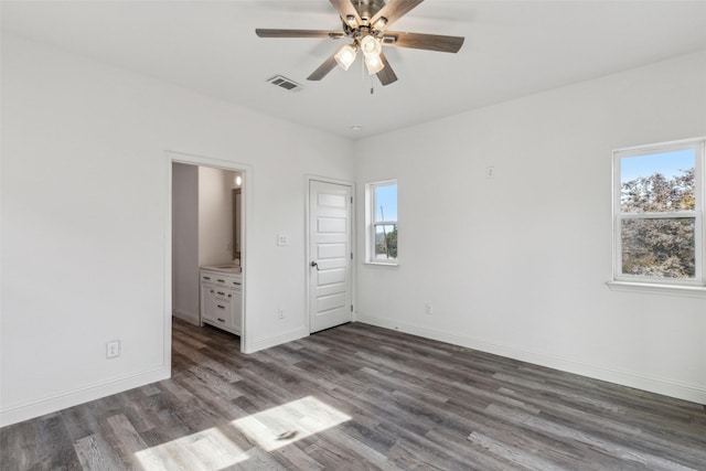 unfurnished bedroom featuring ceiling fan, ensuite bath, and dark hardwood / wood-style flooring