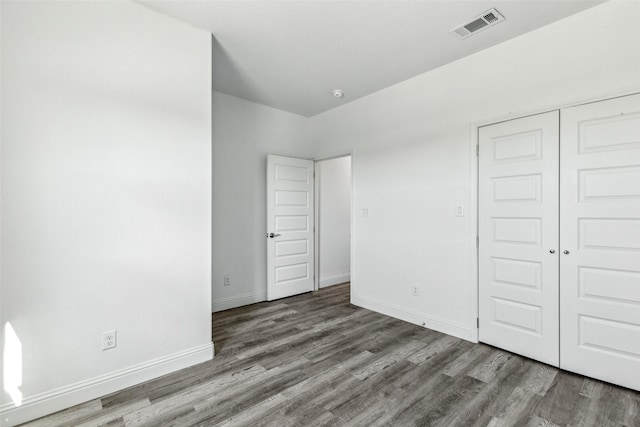 unfurnished bedroom featuring hardwood / wood-style floors and a closet