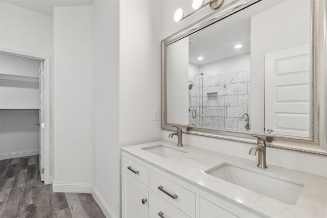 bathroom with wood-type flooring, vanity, and walk in shower