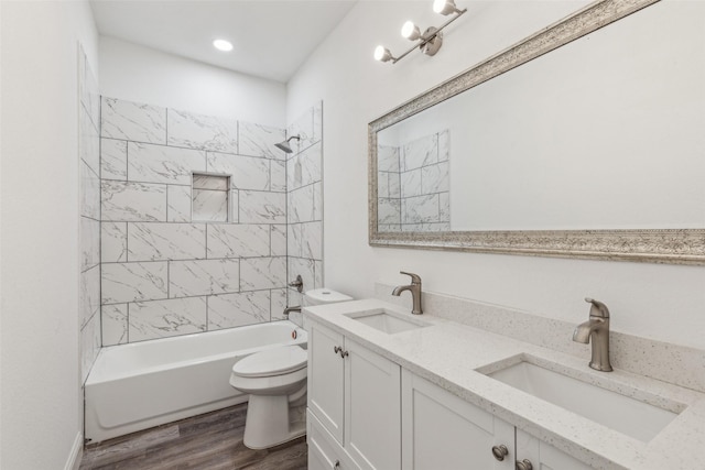 full bathroom with vanity, hardwood / wood-style floors, toilet, and tiled shower / bath