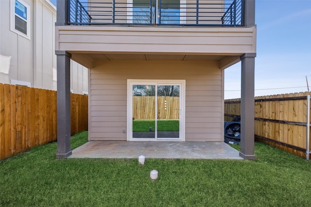 exterior space featuring a balcony, a patio area, and a lawn