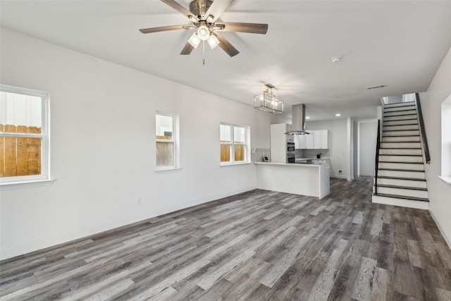 unfurnished living room featuring dark hardwood / wood-style flooring and ceiling fan