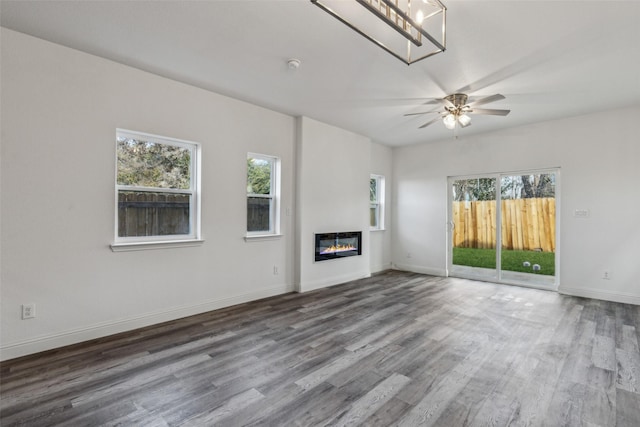 unfurnished living room with ceiling fan, wood-type flooring, and a healthy amount of sunlight