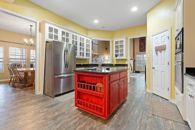 kitchen featuring appliances with stainless steel finishes, a kitchen island with sink, and white cabinets