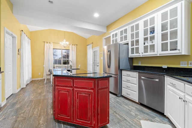 kitchen featuring appliances with stainless steel finishes, dark hardwood / wood-style floors, a center island, and white cabinets