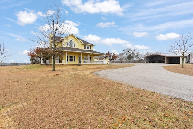 view of front of property with a front yard, a carport, and covered porch