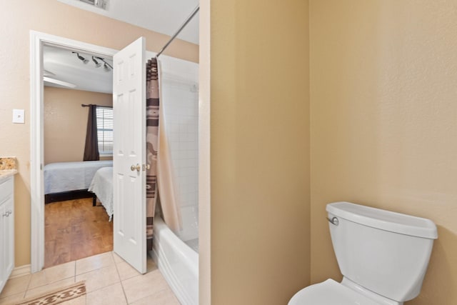 full bathroom featuring vanity, shower / bath combo, tile patterned floors, and toilet