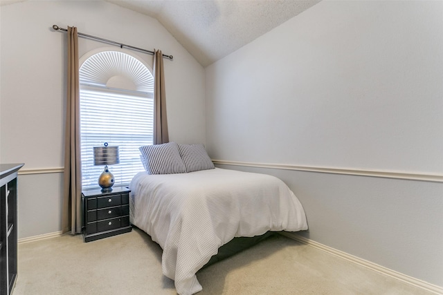 bedroom featuring lofted ceiling and light carpet