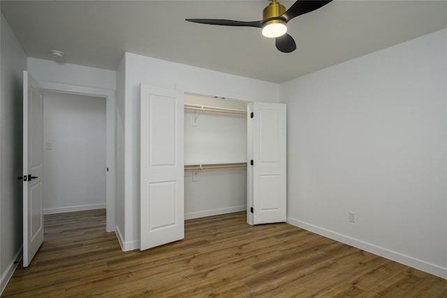 unfurnished bedroom with wood-type flooring, ceiling fan, and a closet