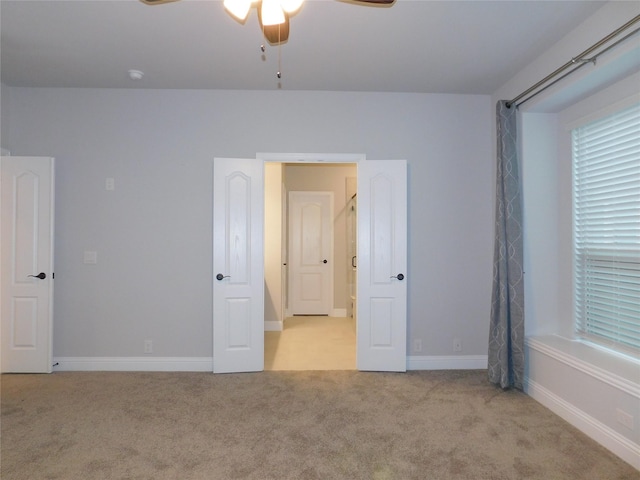 unfurnished bedroom featuring light carpet and ceiling fan