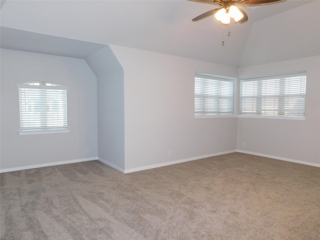 interior space with ceiling fan, lofted ceiling, and light carpet