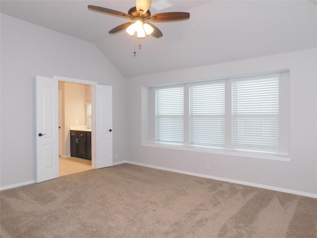 carpeted spare room featuring vaulted ceiling and ceiling fan