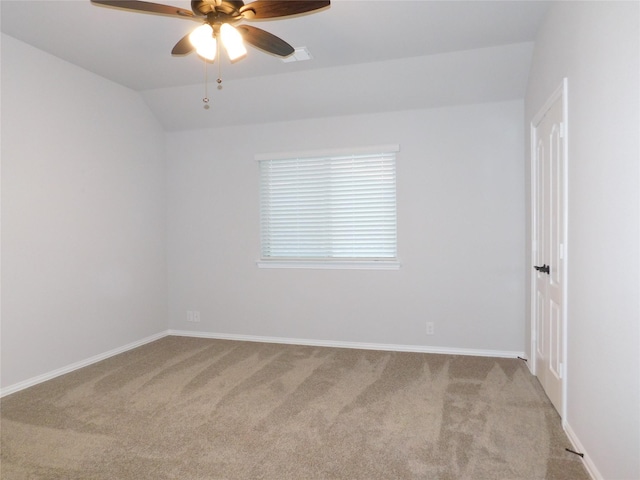 empty room featuring ceiling fan, light colored carpet, and vaulted ceiling