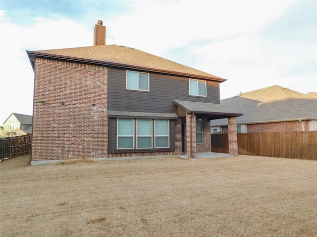 back of house with a patio area and a lawn