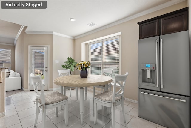 dining space with ornamental molding, a wealth of natural light, and light tile patterned floors