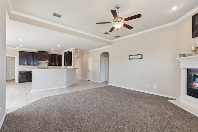 unfurnished living room with crown molding, light colored carpet, and ceiling fan