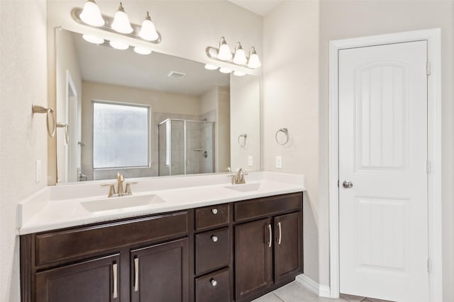 bathroom featuring tile patterned floors, vanity, and a shower with shower door