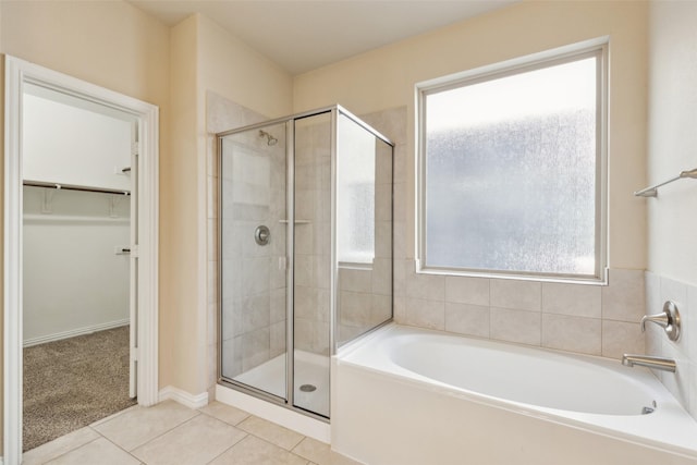 bathroom with tile patterned flooring and separate shower and tub