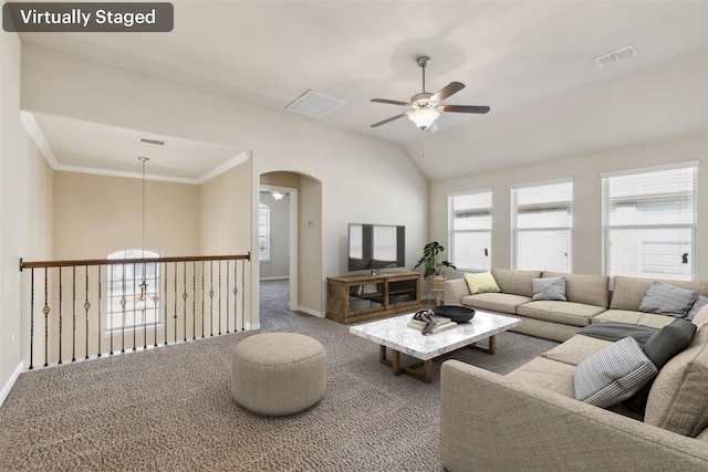 carpeted living room with ceiling fan, ornamental molding, and vaulted ceiling